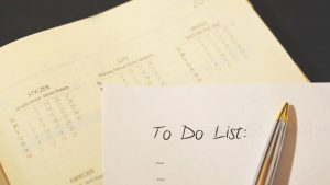 Close-up of a calendar and to-do list on a desk, emphasizing planning and organization.